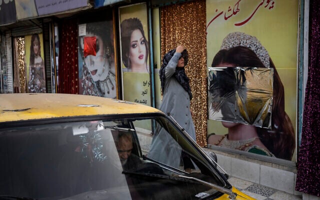 A woman walks past beauty salons with window decorations which have been defaced in Kabul, Afghanistan, Sept. 12, 2021 (AP Photo/Bernat Armangue) A woman walks past beauty salons with window decorations which have been defaced in Kabul, Afghanistan, Sept. 12, 2021 (AP Photo/Bernat Armangue)