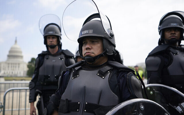 Police in riot gear patrol as people attend a rally near the US Capitol in Washington, Saturday, September 18, 2021. (AP/Brynn Anderson)