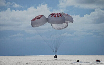 In this image taken provided by SpaceX, a capsule carrying four people parachutes into the Atlantic Ocean off the Florida coast, Saturday, Sept. 18, 2021. (SpaceX via AP)