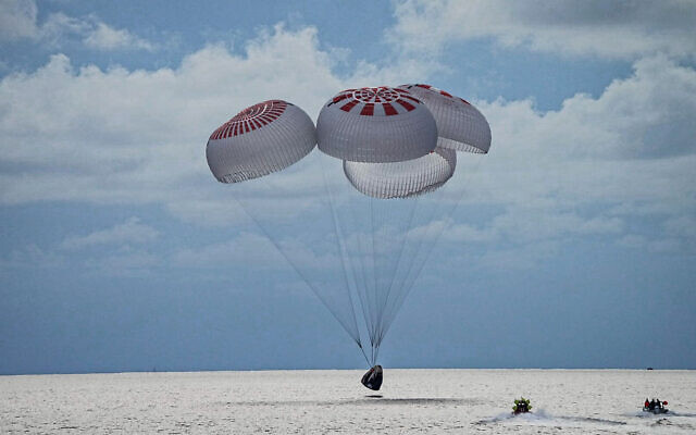 In this image taken provided by SpaceX, a capsule carrying four people parachutes into the Atlantic Ocean off the Florida coast, Saturday, Sept. 18, 2021. (SpaceX via AP)
