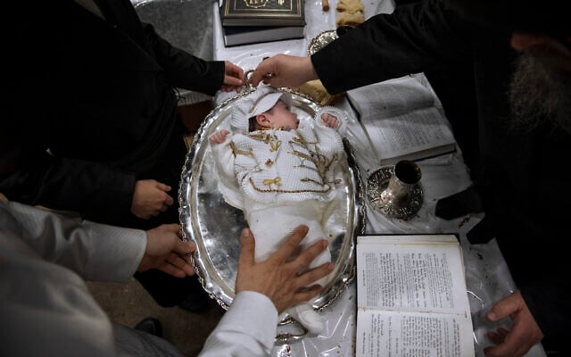 Yaakov Tabersky, lest, presented his firstborn son, Yossef on a silver platter to Jewish priests from the Lelov Hassidic dynasty, during the "Pidyon Haben" ceremony in Beit Shemesh, Israel, on September 16, 2021. (AP/Oded Balilty)