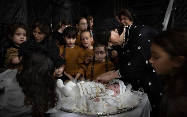 Ultra-Orthodox Jewish women adorn 30-day-old Yossef Tabersky, the great grandchild of the chief rabbi of the Lelov Hassidic dynasty, during the "Pidyon Haben" ceremony in Beit Shemesh, Israel, on September 16, 2021. (AP/Oded Balilty)