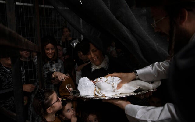 Ultra-Orthodox Jews are holding 30-day-old Yossef Tabersky, the great grandchild of the chief rabbi of the Lelov Hassidic dynasty, during the "Pidyon Haben" ceremony in Beit Shemesh, Israel, on September 16, 2021. (AP Photo/Oded Balilty)