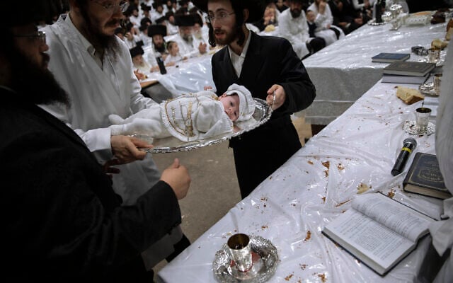 Yaakov Tabersky, right, presented his firstborn son, Yossef on a silver platter to Jewish priests from the Lelov Hassidic dynasty, during the "Pidyon Haben" ceremony in Beit Shemesh, Israel, on September 16, 2021. (AP/Oded Balilty)