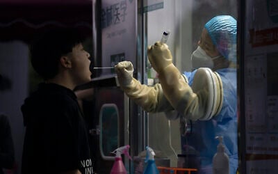 A man gets swapped during a nuclei test for COVID-19 in Beijing Sept. 18, 2021 (AP Photo/Ng Han Guan)