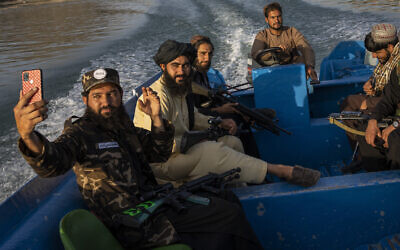 Taliban fighters take a selfie while enjoying a boat ride in the Qargha dam, outskirt of Kabul, Afghanistan, September 24, 2021. (AP Photo/Bernat Armangue)