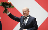 Olaf Scholz, top candidate for chancellor of the Social Democratic Party (SPD), holds a bunch of flowers after a press statement at the party's headquarter in Berlin, Germany, Monday, September 27, 2021.  (AP Photo/Lisa Leunter)