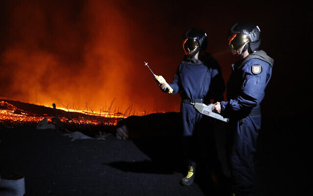 In this photo made available by Ume (Unidad Militar de Emergencias), Military Emergency Unit personal take gas reading measurements near a volcano on the Canary island of La Palma, Spain, in the early hours of Sept. 28, 2021 (Luismi Ortiz/UME via AP) In this photo made available by Ume (Unidad Militar de Emergencias), Military Emergency Unit personal take gas reading measurements near a volcano on the Canary island of La Palma, Spain, in the early hours of Sept. 28, 2021 (Luismi Ortiz/UME via AP)