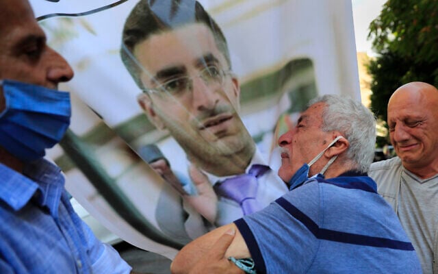 The father of Ibrahim Harb (center), a Lebanese man who was critically injured in the massive explosion at Beirut's port last year and who died on Monday nearly 14 months after the blast, mourns on his son's portrait during his funeral procession, in Beirut, Lebanon, on Tuesday, September 28, 2021. (AP Photo/Hussein Malla) The father of Ibrahim Harb (center), a Lebanese man who was critically injured in the massive explosion at Beirut's port last year and who died on Monday nearly 14 months after the blast, mourns on his son's portrait during his funeral procession, in Beirut, Lebanon, on Tuesday, September 28, 2021. (AP Photo/Hussein Malla)