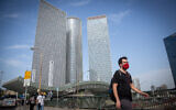 Illustrative: Israelis wear protective face masks near the Azrieli towers in Tel Aviv, on October 25, 2020. (Miriam Alster/Flash90)