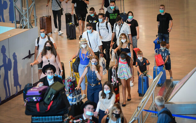 Travelers wear protective face masks inside Ben Gurion International Airport on August 5, 2021. (Avshalom Sassoni/FLASH90) Travelers wear protective face masks inside Ben Gurion International Airport on August 5, 2021. (Avshalom Sassoni/FLASH90)