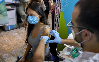 An Israeli woman receives a third dose of the COVID-19 vaccine at a Clalit clinic on September 1, 2021 in Jerusalem. (Olivier Fitoussi/Flash90)