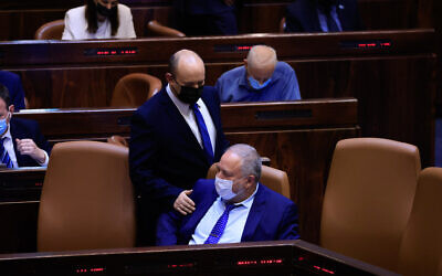 Prime Minister Naftali Bennett seen with Finance Minister Avigdor Liberman during a vote on the first reading of the state budget in the Knesset, September 2, 2021. (Olivier Fitoussi/Flash90)