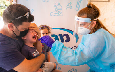 Healthcare workers take COVID-19 test samples of Israelis at a Maccabi healthcare test center in Modiin, on September 13 2021. (Yossi Aloni/Flash90)