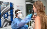 A Magen David Adom volunteer takes a swab sample from an Israeli woman at a coronavirus testing site in the Golan Heights town of Katzrin, on September 15, 2021. (Michael Giladi/Flash90)