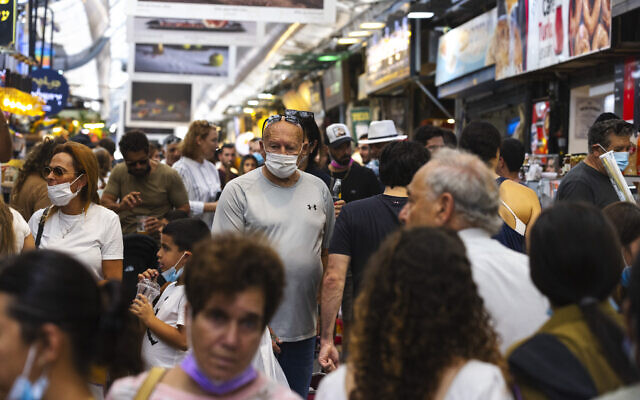 People, some wearing face masks, shop at the Mahane Yehuda market in Jerusalem, on September 20, 2021. (Olivier Fitoussi/Flash90) People, some wearing face masks, shop at the Mahane Yehuda market in Jerusalem, on September 20, 2021. (Olivier Fitoussi/Flash90)