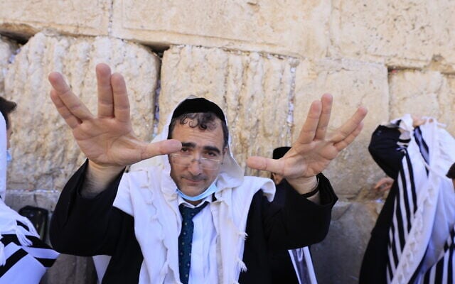 Worshippers pray in front of the Western Wall in Jerusalem's Old City, during the priestly blessing for the festival of Sukkot, on September 22, 2021. (Olivier Fitoussi/Flash90)