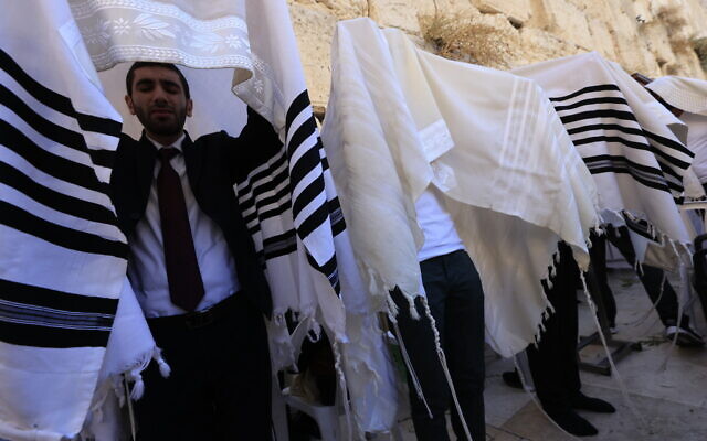 Worshippers pray in front of the Western Wall in Jerusalem's Old City, during the priestly blessing for the festival of Sukkot, on September 22, 2021. (Olivier Fitoussi/Flash90)