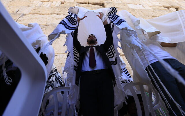 Worshippers pray in front of the Western Wall in Jerusalem's Old City, during the priestly blessing for the festival of Sukkot, on September 22, 2021. (Olivier Fitoussil/Flash90)