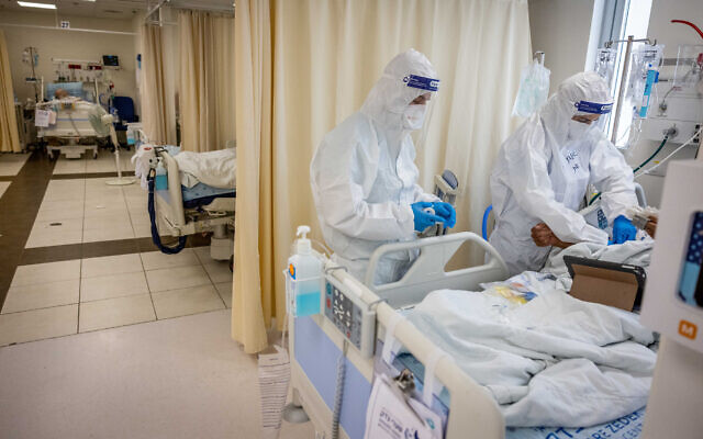 Hospital staff tend to a patient in the coronavirus ward at Shaare Zedek Medical Center in Jerusalem, on September 23, 2021. (Yonatan Sindel/ Flash90) Hospital staff tend to a patient in the coronavirus ward at Shaare Zedek Medical Center in Jerusalem, on September 23, 2021. (Yonatan Sindel/ Flash90)