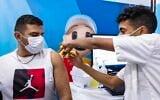 An Israeli receives a dose of the COVID-19 vaccine at a temporary Clalit Health Services facility in Jerusalem, September 26, 2021. (Olivier Fitoussi/Flash90)