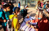 Young Israeli students have their antigen test results checked as they arrive for their first day of school after the holidays, at Aseh Hayil school in the West Bank settlement of Efrat, September 30, 2021 (Gershon Elinson/Flash90)