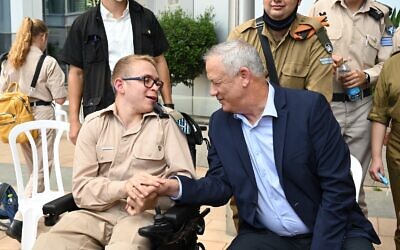 Defense Minister Benny Gantz, right, shakes hands with an IDF soldier during an event for the Sukkot holiday at the military's Kirya headquarters in Tel Aviv on September 23, 2021. (Tal Oz/Defense Ministry)