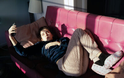 Illustrative: A teenager looks at her mobile phone while quarantining (Maria Casinos; iStock by Getty Images)