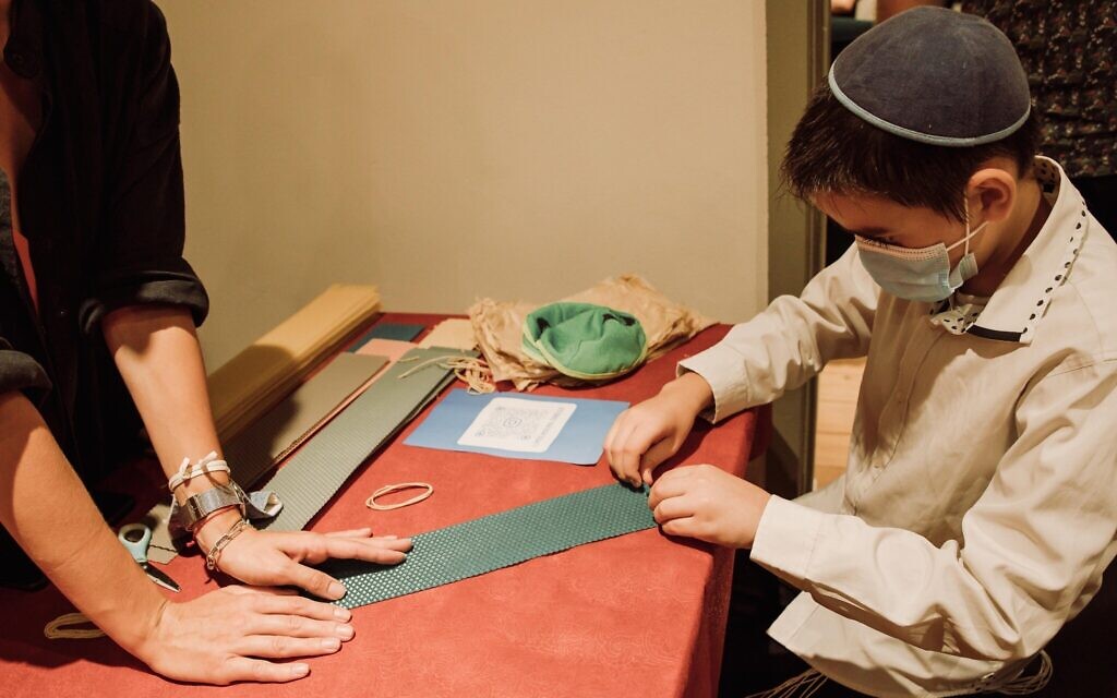 A young boy learns how to make homemade candles for Rosh Hashanah at the grand opening of Jewish Point's synagogue in Tel Aviv, August 26, 2021. It is the city's first congregation geared specifically towards Russian speakers. (Courtesy)