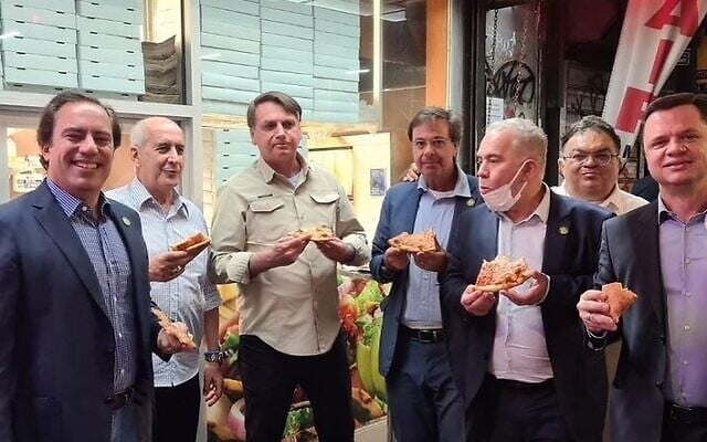 Brazilian President Jair Bolsonaro, center left, eats pizza on a New York sidewalk in a photo uploaded to social media on September 20, 2021. (Tourism Minister Gilson Machado/Instagram) Brazilian President Jair Bolsonaro, center left, eats pizza on a New York sidewalk in a photo uploaded to social media on September 20, 2021. (Tourism Minister Gilson Machado/Instagram)