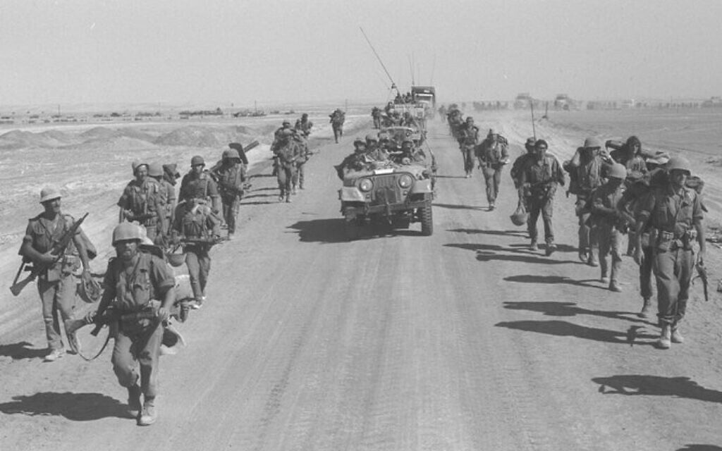 Israeli paratroopers march along the Suez-Cairo road after crossing the Suez Canal, October 1973. (Ron Ilan/GPO)