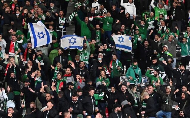 Israel's Maccabi Haifa fans display Israeli flags in the stands, during the UEFA Conference League Group E first leg football match between FC Union Berlin and Maccabi Haifa in the Olympic Stadium in Berlin, on September 30, 2021. (Matthias Koch/DPA/AFP/Germany Out) Israel's Maccabi Haifa fans display Israeli flags in the stands, during the UEFA Conference League Group E first leg football match between FC Union Berlin and Maccabi Haifa in the Olympic Stadium in Berlin, on September 30, 2021. (Matthias Koch/DPA/AFP/Germany Out)