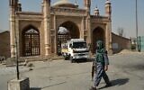 A Taliban fighter walks past the entrance of the Eid Gah mosque where a blast struck a day before, in Kabul on October 4, 2021. (Hoshang Hashimi / AFP)