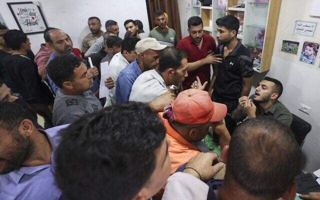 Palestinian men gather to apply for work permits in Israel, at Jabalia refugee camp in the northern Gaza Strip, on October 6, 2021. (Mahmud Hams/AFP)