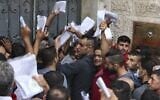 Palestinian men gather to apply for work permits in Israel, at Jabalia refugee camp in the northern Gaza Strip, on October 6, 2021. (Mahmud Hams/AFP)