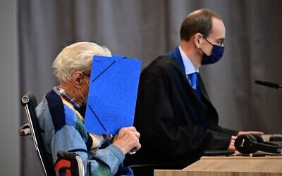 Defendant Josef S (L) sits next to his lawyer Stefan Waterkamp and hides his face behind a folder as he waits for the start of his trial in Brandenburg an der Havel, northeastern Germany, on October 7, 2021. (Tobias Schwarz / AFP)
