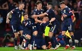 Scotland players celebrate after wining the FIFA World Cup Qatar 2022 Group F qualification football match between Scotland and Israel at Hampden Park in Glasgow on october 9, 2021. (ANDY BUCHANAN / AFP)