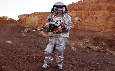 An astronaut from a team from Europe and Israel and dressed in a spacesuit holds a quadcopter drone during a training mission for planet Mars at a site that simulates an off-site station at the Ramon Crater in Mitzpe Ramon in Israel's southern Negev desert on October 10, 2021. (Photo by JACK GUEZ / AFP)