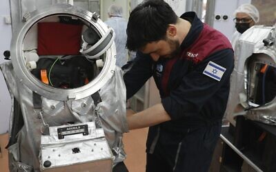 Israeli astronaut Alon Tenzer prepares his spacesuit before starting a training mission for planet Mars at a site that simulates an off-site station at the Ramon Crater in Mitzpe Ramon in Israel's southern Negev desert on October 10, 2021. (Photo by JACK GUEZ / AFP)