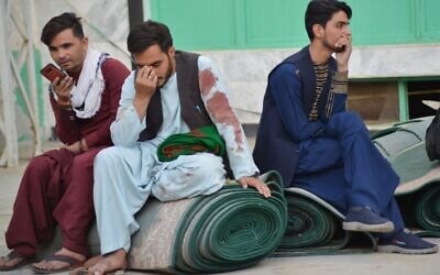 Afghan men sit in a courtyard inside a Shiite mosque in Kandahar on October 15, 2021, after a suicide bomb attack during Friday prayers (Javed TANVEER / AFP)