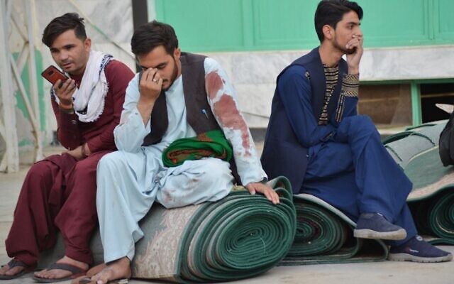 Afghan men sit in a courtyard inside a Shiite mosque in Kandahar on October 15, 2021, after a suicide bomb attack during Friday prayers (Javed TANVEER / AFP)