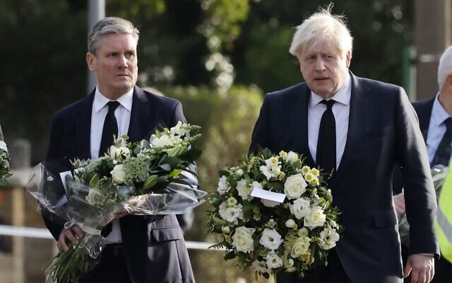 Britain's Prime Minister Boris Johnson (right) and Britain's main opposition Labour Party leader Keir Starmer carry floral tributes as they arrive at the scene of the fatal stabbing of Conservative British lawmaker David Amess, at Belfairs Methodist Church in Leigh-on-Sea, a district of Southend-on-Sea, in southeast England, on October 16, 2021 (Tolga Akmen/AFP) Britain's Prime Minister Boris Johnson (right) and Britain's main opposition Labour Party leader Keir Starmer carry floral tributes as they arrive at the scene of the fatal stabbing of Conservative British lawmaker David Amess, at Belfairs Methodist Church in Leigh-on-Sea, a district of Southend-on-Sea, in southeast England, on October 16, 2021 (Tolga Akmen/AFP)