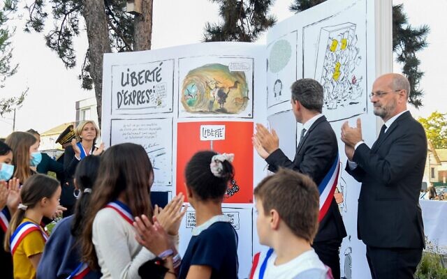 French Education Minister Jean-Michel Blanquer (righ) while unveiling a book sculpture as part of a tribute ceremony to French teacher Samuel Paty, in Conflans-Saint-Honorine, northwestern Paris, on October 16, 2021, one year after Paty was beheaded by an extremist after showing his class cartoons of the Muslim Prophet Mohammed. (Alain Jocard/AFP)