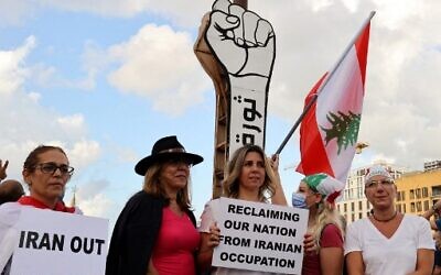 Protesters gather in front of the 'Revolution fist' symbol of Lebanon's October 2019 uprising, during a rally in the capital Beirut's Martyrs Square, on October 17, 2021. (ANWAR AMRO / AFP)