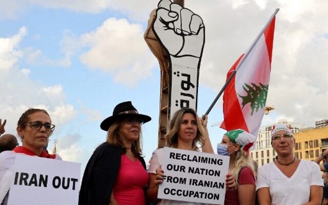 Protesters gather in front of the 'Revolution fist' symbol of Lebanon's October 2019 uprising, during a rally in the capital Beirut's Martyrs Square, on October 17, 2021. (ANWAR AMRO / AFP) Protesters gather in front of the 'Revolution fist' symbol of Lebanon's October 2019 uprising, during a rally in the capital Beirut's Martyrs Square, on October 17, 2021. (ANWAR AMRO / AFP)