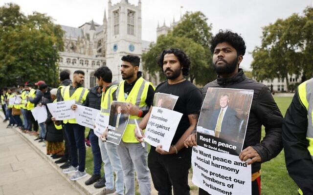 Members of the Freedom Hunters For Tamils rights activist organization hold up photographs and placards in honor of killed British lawmaker David Amess as they line Parliament Square in front of the Houses of Parliament in central London on October 18, 2021. (Tolga Akmen / AFP) Members of the Freedom Hunters For Tamils rights activist organization hold up photographs and placards in honor of killed British lawmaker David Amess as they line Parliament Square in front of the Houses of Parliament in central London on October 18, 2021. (Tolga Akmen / AFP)