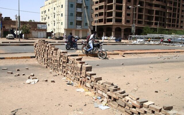 Sudanese anti-coup protesters use bricks to barricade a street in the capital Khartoum on October 27, 2021, amid ongoing demonstrations against a military takeover that has sparked widespread international condemnation. (AFP)