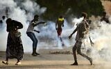 Sudanese youths confront security forces amidst tear gas fired by them to disperse protesters in the capital Khartoum, on October 27, 2021, amid ongoing demonstrations against a military takeover that has sparked widespread international condemnation. (AFP)
