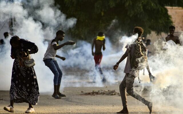 Sudanese youths confront security forces amidst tear gas fired by them to disperse protesters in the capital Khartoum, on October 27, 2021. (AFP) Sudanese youths confront security forces amidst tear gas fired by them to disperse protesters in the capital Khartoum, on October 27, 2021. (AFP)