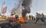Sudanese anti-coup protesters wave the national flag as they gather in a street in the capital Khartoum, on October 30, 2021, to express their support for the country's democratic transition which a military takeover and deadly crackdown derailed. (AFP)